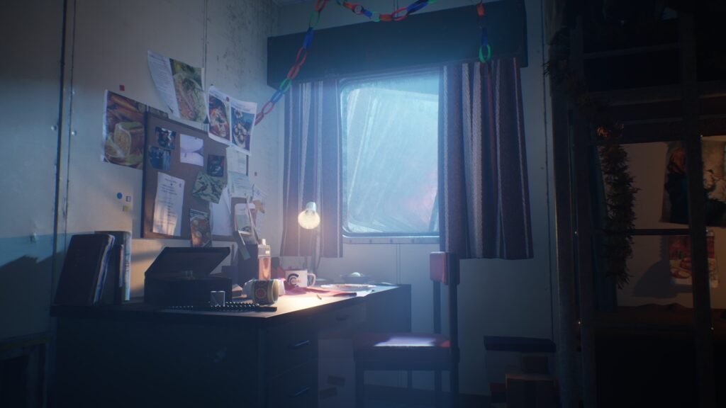 a small bedroom the image shows the desk with some Christmas decorations hanging from the window. the desk lamp is lit illuminating the cluttered desk and pinboard.